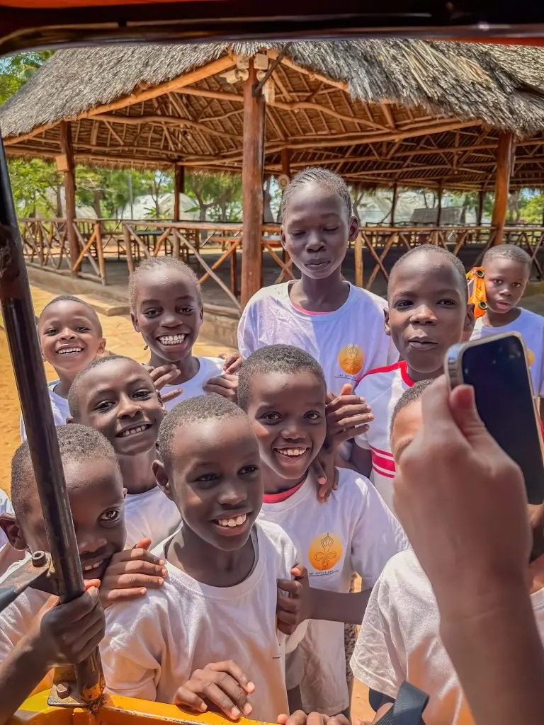 Children smiling looking in at a TukTuk at the Happy House Kenya