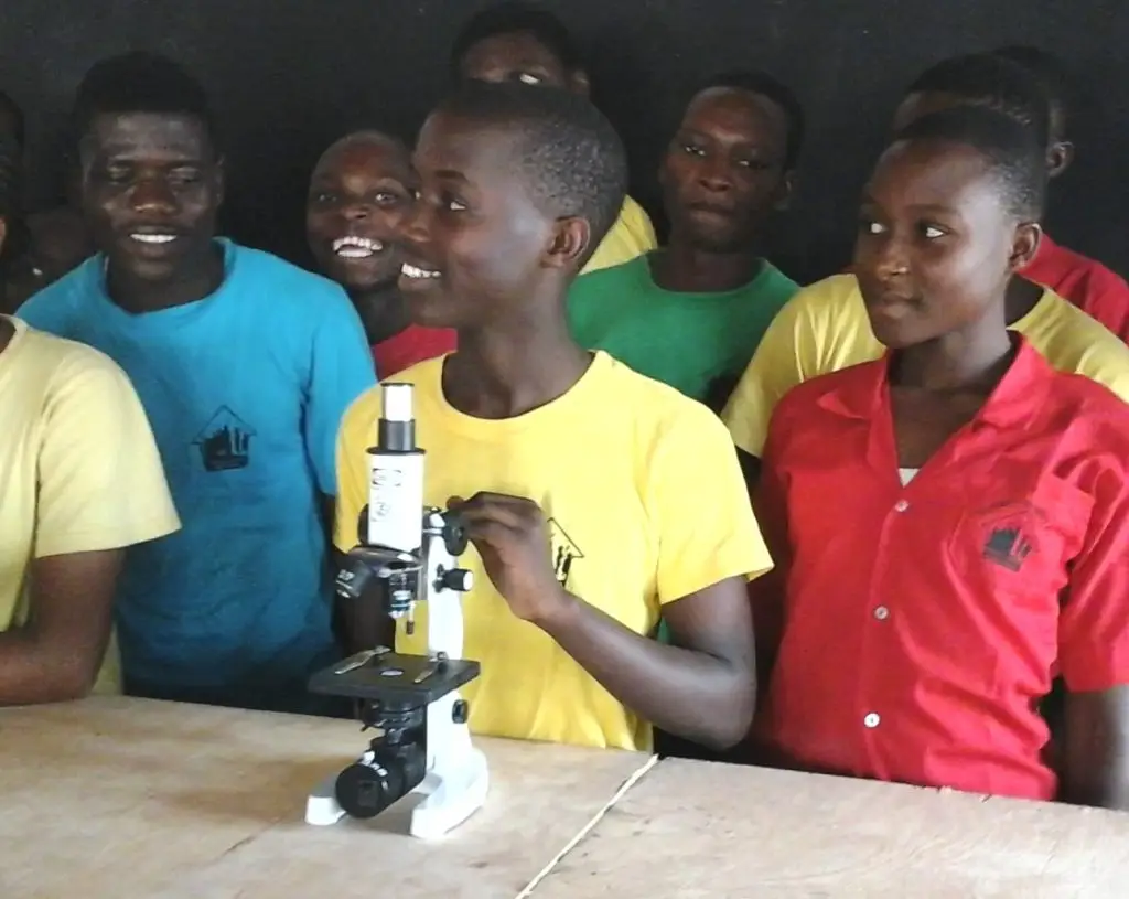 A student in the happy house school using a microscope